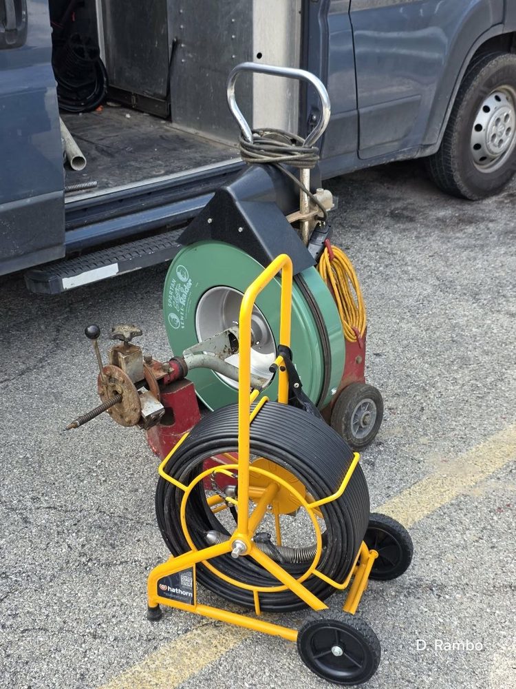 Sewer inspection camera on a yellow cart with coiled cable
