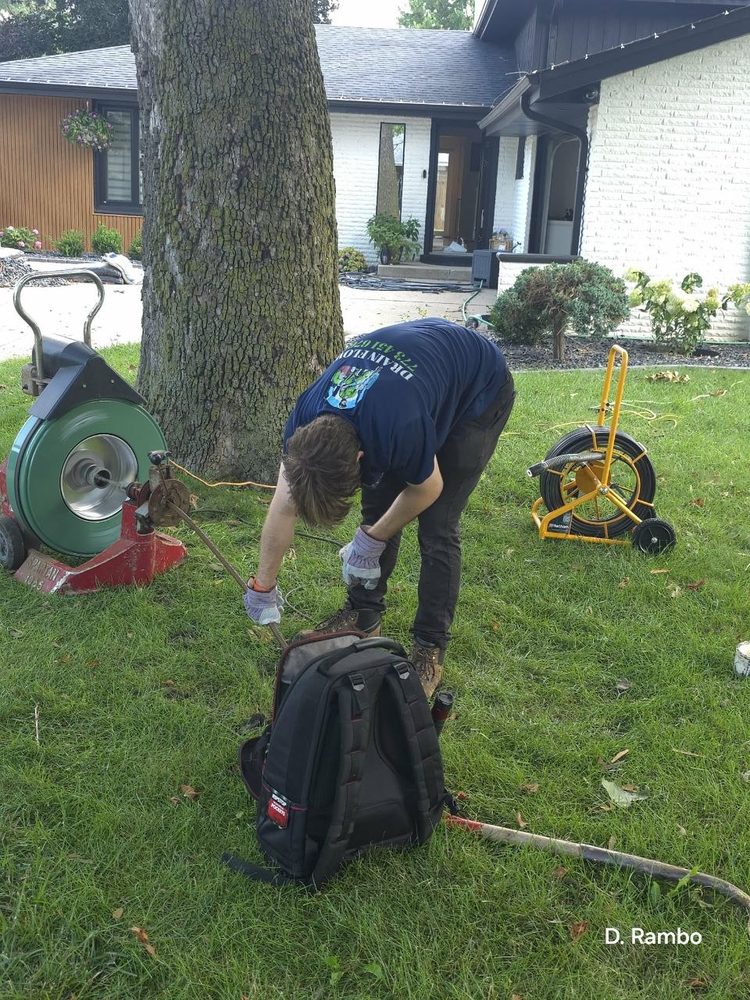 Technician clearing a sewer line on a residential lawn