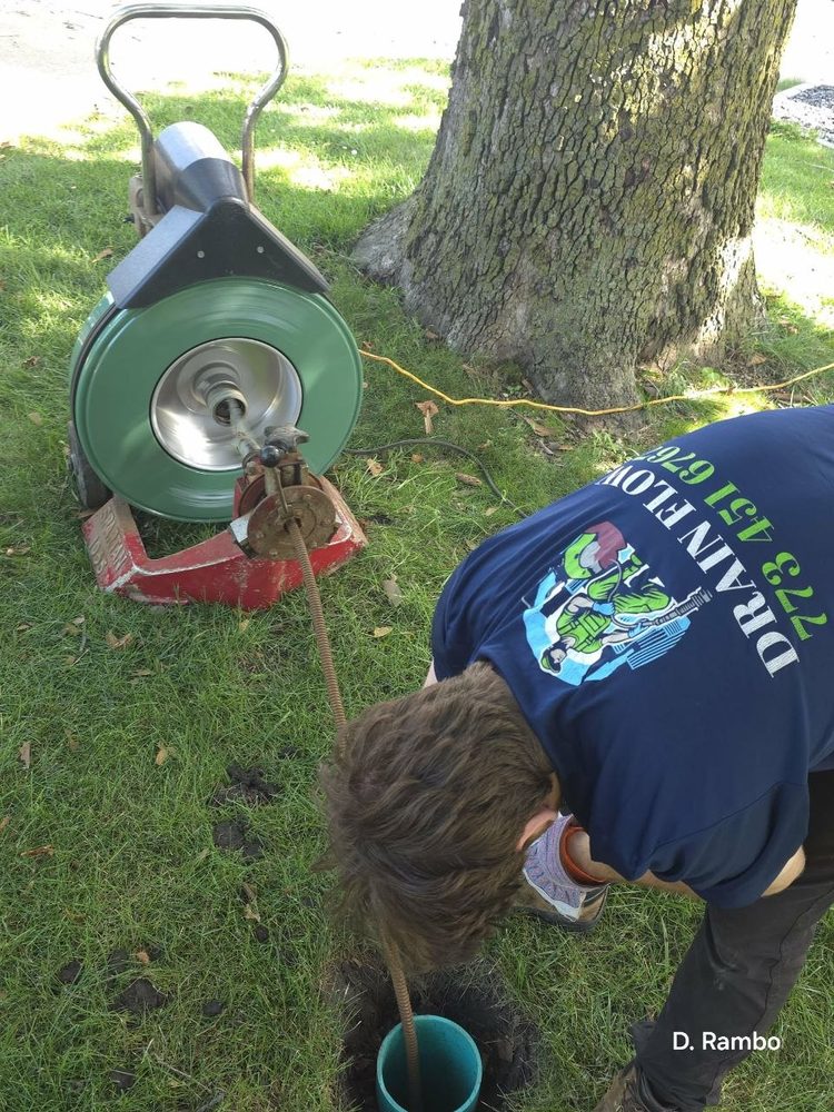 Power rodding machine clearing a cleanout on a lawn
